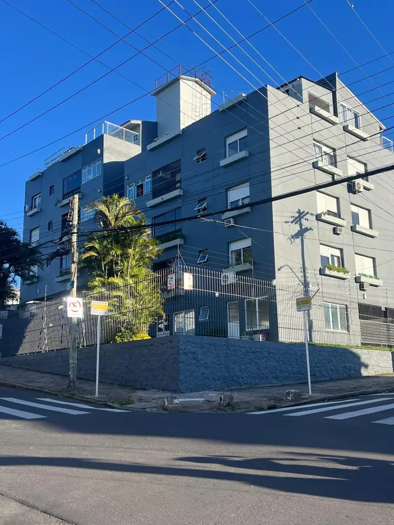 Edifício cinza de esquina com muro texturizado