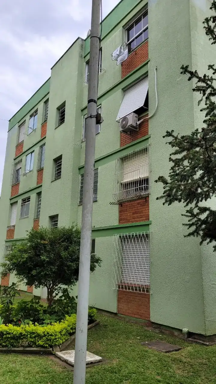 Fachada verde de prédio com faixas e detalhes em tijolo